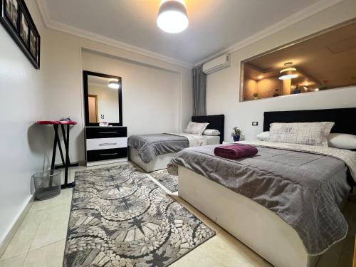 Un dormitorio con dos camas y un espejo. en Hi Pyramids, en El Cairo