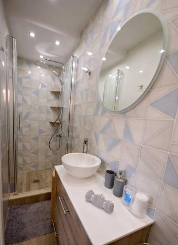 łazienka z umywalką i prysznicem z lustrem w obiekcie Lia's apartment w mieście Kalimnos