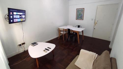 sala de estar con 2 mesas y TV en Tourist Apartment San Telmo en Buenos Aires