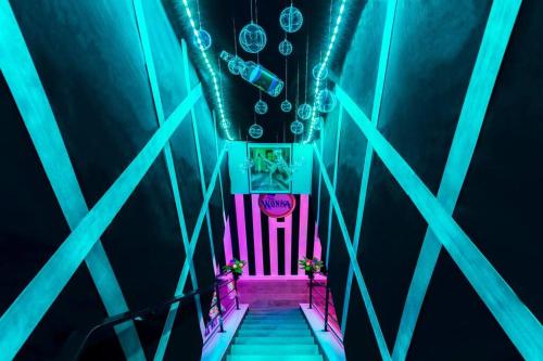 un escalier aux lumières bleue et rose dans l'établissement King Bed / Free Parking / Arcade / BBQ / Patio, à Pittsburgh
