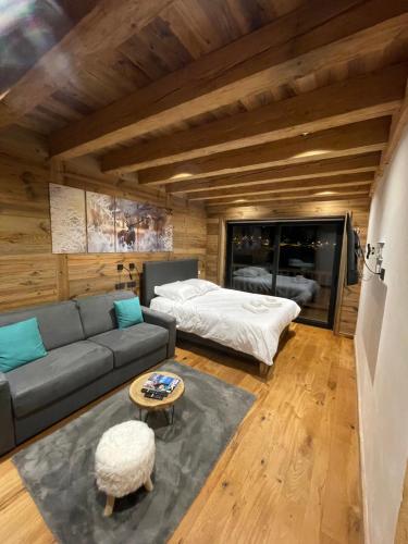 a living room with a couch and a bed at Appartement haut standing Arêches beaufort in Arêches