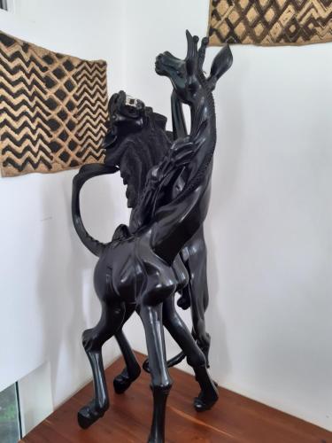 a bronze statue of a woman and a dog on a table at Themi View in Arusha