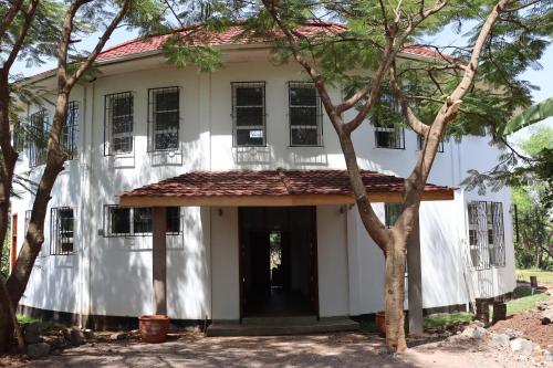 a white house with trees in front of it at Themi View in Arusha