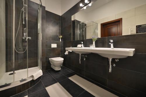 a bathroom with a sink and a shower and a toilet at City Hotel Morris in Česká Lípa