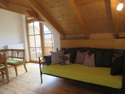 a living room with a green couch with pillows at Landhaus Familie Doll Ferienwohnung Sunnawind in Bichl