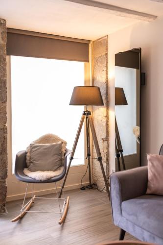 un salon avec une chaise et une lampe dans l'établissement CONFORTABLE 2 PIÈCES AU CŒUR DU CENTRE HISTORIQUE, à Vienne