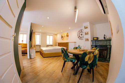 a room with a table and chairs and a bed at Apartament Książęcy Gold klimatyzacja in Bolesławiec
