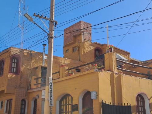 a yellow building with a tower on top of it at Carnavalito Hostel Tilcara in Tilcara