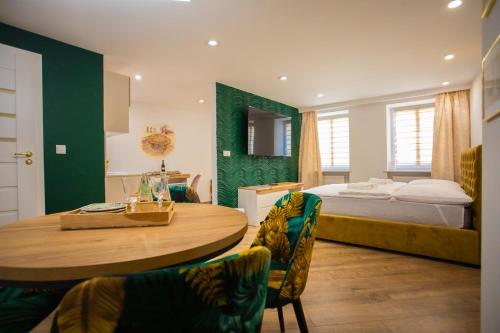 a bedroom with a bed and a table and chairs at Apartament Książęcy Gold klimatyzacja in Bolesławiec