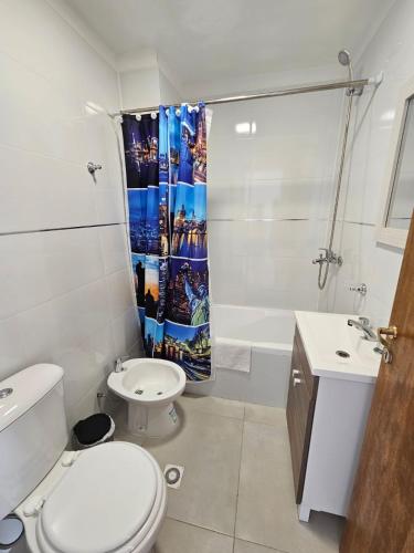 a bathroom with a toilet and a shower curtain at Xalpen Ushuaia in Ushuaia