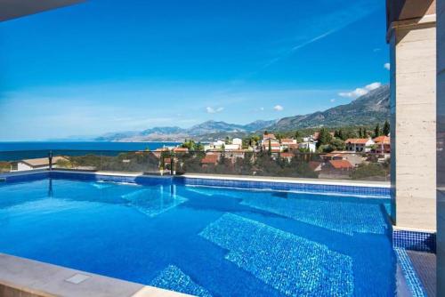 a large swimming pool with a view of the ocean at Minna Apartments in Utjeha