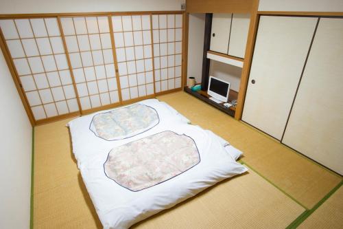 a room with two mats on the floor at 駅前山小屋A-yard in Ome