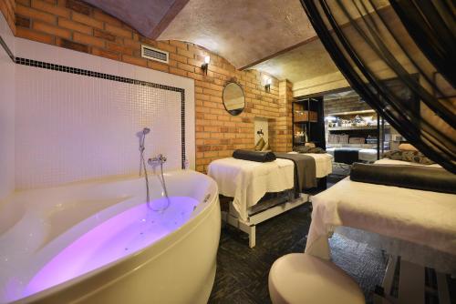 a bathroom with a tub and a room with beds at City Hotel Morris in Česká Lípa