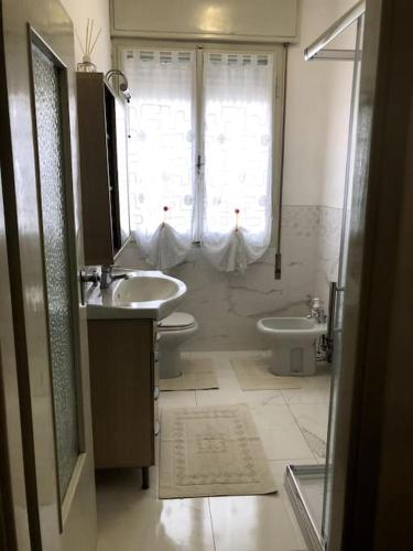 a bathroom with a sink and a toilet and a window at B&B da Fiore in Castel Bolognese