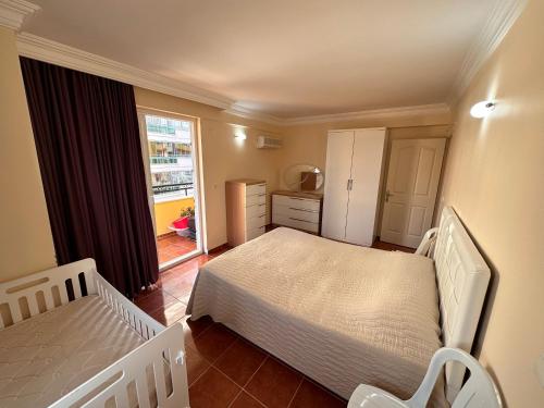 Holiday Residence with Pool في ألانيا: غرفة نوم صغيرة بسريرين ومطبخ