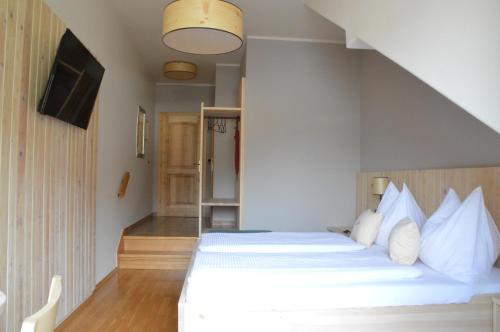 a bedroom with a bed with white pillows at Gasthof zur Donaubrücke in Ardagger Markt