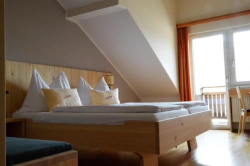 a bedroom with a bed with white pillows at Gasthof zur Donaubrücke in Ardagger Markt
