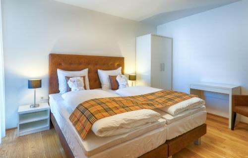 a bedroom with a large bed with a wooden headboard at Residence Bellevue - incl Summercard in Zell am See