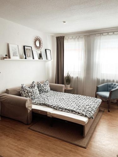 a bed in a room with a couch and a window at **TOP**GEMÜTLICH*BERGNAH*ZENTRAL*NETFLIX & RELAX* in Sonthofen
