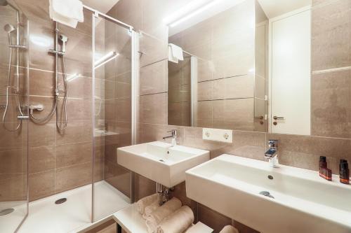 a bathroom with a sink and a shower and a mirror at Residence Bellevue - incl Summercard in Zell am See