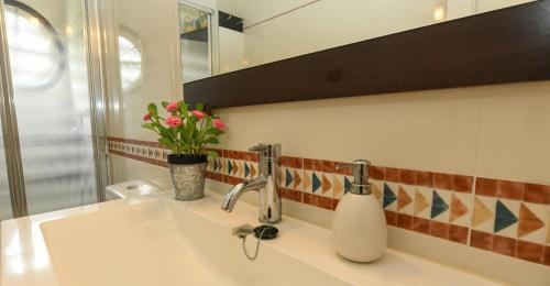 La salle de bains est pourvue d'un lavabo et d'un vase de fleurs. dans l'établissement CASA VIVA, à Santa Cruz de la Palma