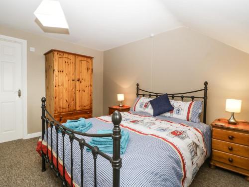 a bedroom with a bed and a wooden cabinet at 8A Rosewood Avenue in Burnham on Sea