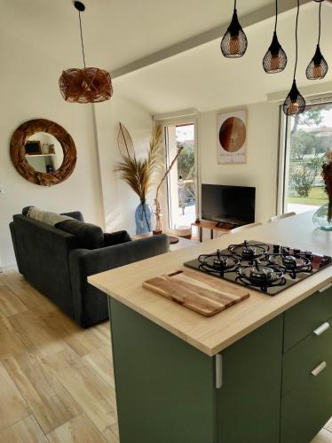 Il comprend une cuisine et un salon avec une cuisinière. dans l'établissement Maisonnette neuve plage et commerces à pied, à Vieux-Boucau-les-Bains