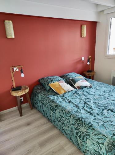 une chambre avec un lit et un mur rouge dans l'établissement Maisonnette neuve plage et commerces à pied, à Vieux-Boucau-les-Bains