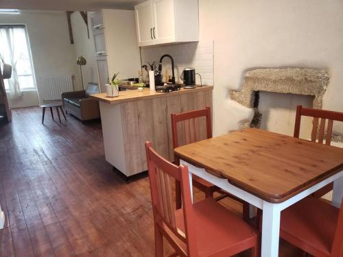 une cuisine et une salle à manger avec une table en bois et des chaises dans l'établissement Studio au centre de Guémené-sur-Scorff, à Guéméné-sur-Scorff