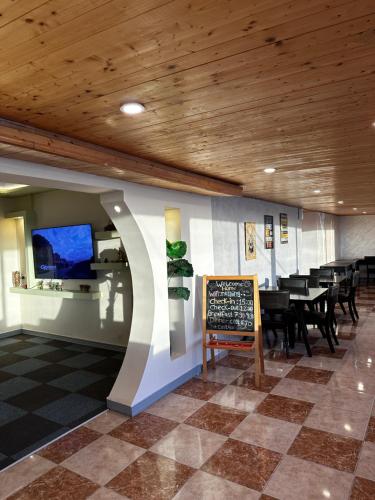 a restaurant with tables and a chalkboard on a wall at Rafiki Hostel in Wadi Musa