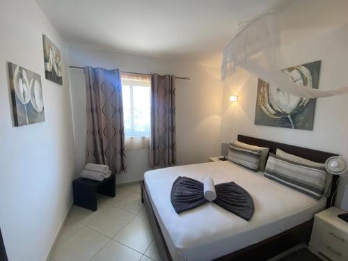 Un dormitorio con una cama con una pajarita. en Quality Melia Dunas Beach Resort Apt Spa Gym 7 Pools, en Santa Maria
