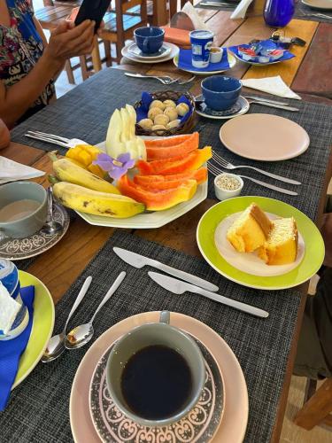 a table with plates of food and a cup of coffee at Pousada Preciosa do Arraial - com Natura e L'Occitane - recém inaugurada in Arraial d'Ajuda