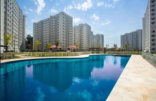 une grande piscine dans une ville avec de grands bâtiments dans l'établissement Ap Barra da Tijuca RJ Praia, à Rio de Janeiro
