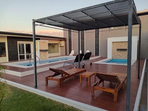 a wooden deck with a patio furniture and a swimming pool at DEL SOL APART TERMAL I in Termas de Río Hondo