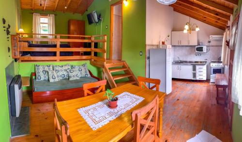 a kitchen and dining room with a table and a bunk bed at Cabañas Posada de las Flores in Tolhuin