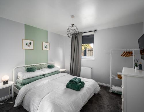 Un dormitorio con una gran cama blanca y una ventana en The School House en Broughty Ferry