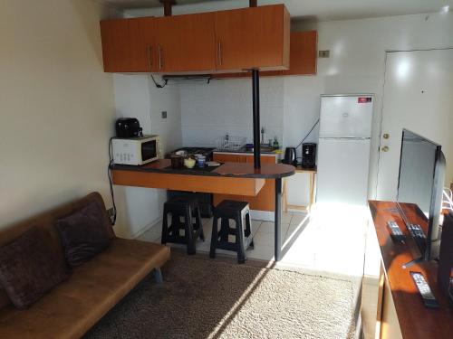 eine kleine Küche mit einem Tisch und einem Kühlschrank in der Unterkunft Apartamento 1 dormitorio estacionamiento Hermosa vista in Concepción