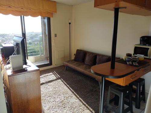 een woonkamer met een bank en een tafel bij Apartamento 1 dormitorio estacionamiento Hermosa vista in Concepción