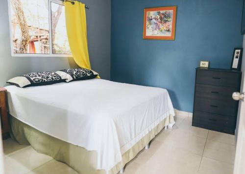 a bedroom with a bed with a dresser and a window at Casa de Campo Villa Carolina en Zambrano in Zambrano