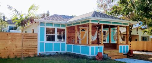 a tiny house with a porch and a fence at The Beachy Bungalow w/King Bed, near Dtwn & Beach in St. Petersburg