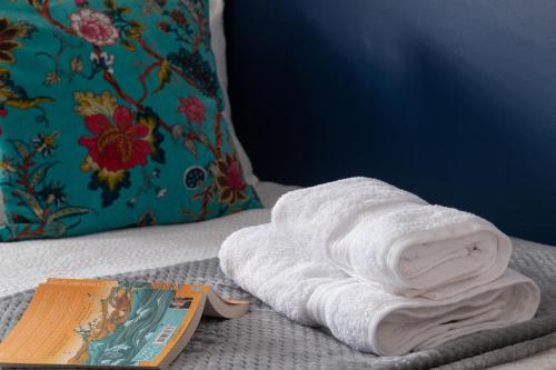 a white towel sitting on a bed next to a book at The Elderton, Newbiggin By The Sea, Northumberland in Newbiggin-by-the-Sea