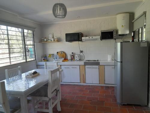 a kitchen with a table and a refrigerator at Casa Quinta Las Casuarinas in Mercedes