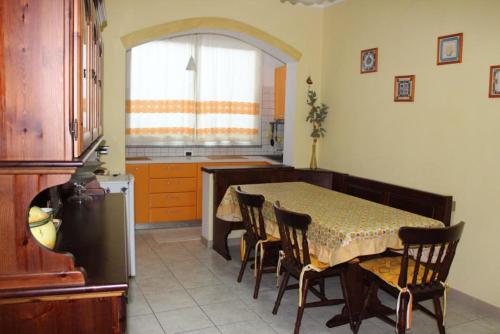 een keuken met een tafel en stoelen en een keuken met een raam bij Casa Vacanze “Dream House” in Scano Montiferro