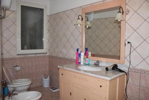 a bathroom with a sink and a toilet and a mirror at Casa Vacanze “Dream House” in Scano Montiferro