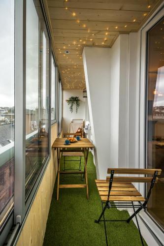 a small balcony with a table and benches on it at Escapade en Bord de mer avec Sauna et Spa Privés in Binic-Etables-sur-Mer