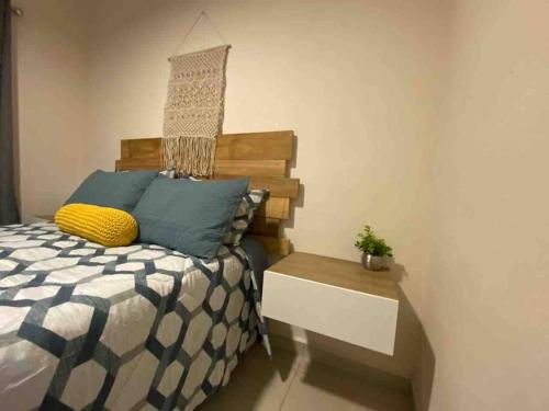 Cycling House في بويرتو فايارتا: غرفة نوم بسرير وطاولة عليها نبات