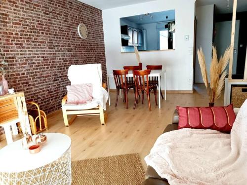- un salon avec un canapé, des chaises et un mur en briques dans l'établissement LE COSY plein centre avec terrasse, à Meximieux