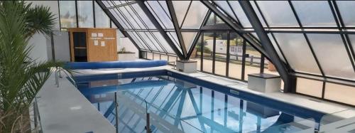 a swimming pool in a building with windows at L'Hippique C.L.S Deauville in Deauville