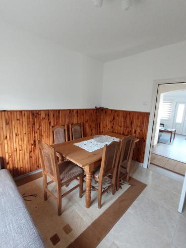 a dining room with a wooden table and chairs at Verina kuća in Kosjerić