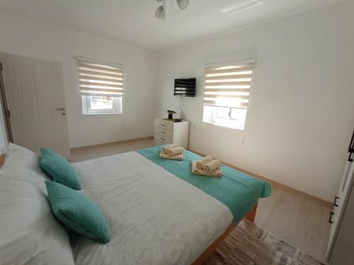 a bedroom with a bed with two towels on it at Verina kuća in Kosjerić